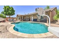 A private backyard oasis features a sparkling pool, lounge chairs, and a basketball hoop for outdoor fun at 8037 W Sweetwater Ave, Peoria, AZ 85381