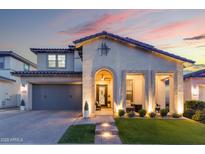 Stunning home featuring desert landscaping, a covered porch with seating and a two car garage at 20921 E Carriage Way, Queen Creek, AZ 85142