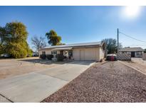 Quaint single-story home featuring solar panels, a driveway, and desert landscaping in a quiet neighborhood at 211 4Th W Ave, Buckeye, AZ 85326