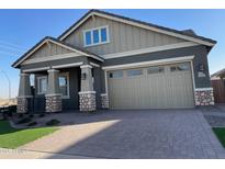 Charming single-Gathering home featuring a two-car garage and a beautifully landscaped front yard and stone accents at 23161 E Mockingbird Dr, Queen Creek, AZ 85142