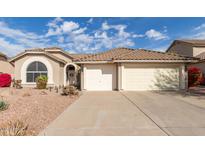 Inviting single-story home with desert landscaping, a tile roof and a convenient three-car garage at 3807 N Kings Peak --, Mesa, AZ 85215