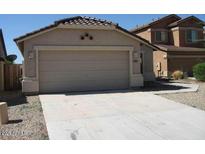 View of the house, with a two-car garage and low maintenance landscaping at 44493 W Cypress Ln, Maricopa, AZ 85138