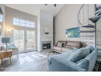 Inviting living room with a fireplace, spiral staircase, and bright natural light at 7675 E Mcdonald Dr # 222, Scottsdale, AZ 85250