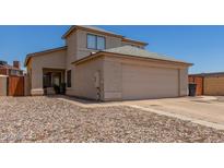 Beige two-story home with a two car garage, desert landscaping, and a well-maintained facade at 11101 N 82Nd Dr, Peoria, AZ 85345