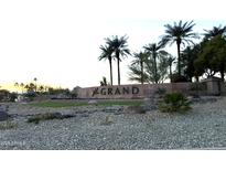 Stone community sign surrounded by desert landscaping and palm trees against a bright sky at 15712 W Eucalyptus Ct, Surprise, AZ 85374