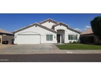 Charming single-story home featuring a well-manicured lawn, attached two car garage, and neutral colored stucco facade at 15971 N 91St Dr, Peoria, AZ 85382