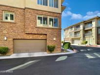 A beige two-car garage with a brick facade on a building in a modern townhome community at 17850 N 68Th St # 2160, Phoenix, AZ 85054