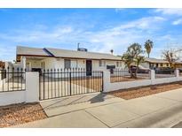 Charming home with a white wall, black wrought iron fence, and manicured front yard at 2053 W Pecan Rd, Phoenix, AZ 85041