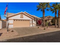 Charming single-story home featuring a two-car garage, desert landscaping, and mature palm trees at 3354 N 157Th Ave, Goodyear, AZ 85395