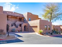 Desert home featuring a private garage and guest entry with gated access to the residence at 36601 N Mule Train Rd # D30, Carefree, AZ 85377