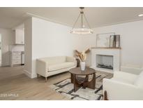 Bright living room with a modern chandelier, fireplace, neutral furniture, and stylish rug at 4307 E Turney Ave, Phoenix, AZ 85018