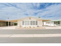 Charming manufactured home with a covered carport and desert landscaping under a bright blue sky at 5735 E Mcdowell Rd # 447, Mesa, AZ 85215