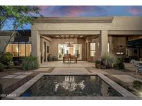 Spacious covered patio featuring an outdoor dining area and serene water feature at 6993 E Soaring Eagle Way, Scottsdale, AZ 85266