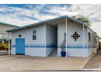 Charming mobile home features light blue trim, an attached garage, and a front porch entrance at 17200 W Bell Rd # 26, Surprise, AZ 85374