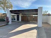 Charming single-story home featuring white pillars, partial privacy fence, and a convenient covered parking area at 1725 N Date -- # 23, Mesa, AZ 85201