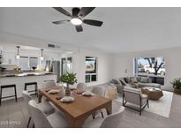 Open-concept living and dining room with modern decor, ceiling fan, and a view to the outside at 1725 N Date -- # 23, Mesa, AZ 85201