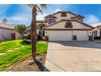 Inviting two-story home with a three-car garage and lush green lawn at 1865 E Pinto Dr, Gilbert, AZ 85296