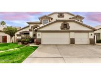 Charming home featuring a well-manicured lawn, three-car garage, and neutral paint scheme at 1865 E Pinto Dr, Gilbert, AZ 85296