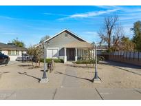 Charming grey home with manicured front yard and inviting entrance, enhancing curb appeal at 215 N Hobson --, Mesa, AZ 85203