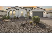 Charming stucco home featuring desert landscaping, a gray garage door and beautiful arched windows at 3539 E Starflower Dr, Queen Creek, AZ 85142