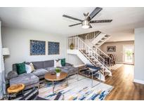 Stylish living room features a plush gray sofa, modern decor, and a staircase leading to the upper level at 5094 N 83Rd St, Scottsdale, AZ 85250