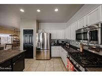 Modern kitchen featuring stainless steel appliances, granite countertops, and white cabinetry at 6640 W Honeysuckle Dr, Phoenix, AZ 85083