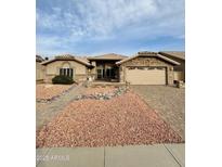 Charming single-story home features a well-manicured yard, stone accents, and a brick-paved driveway to the garage at 8536 W Rockwood Dr, Peoria, AZ 85382