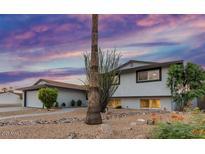 Charming home with drought-resistant landscaping, a new roof, and a tranquil atmosphere at sunset at 8602 E Mitchell Dr, Scottsdale, AZ 85251