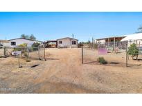 Mobile home behind a chain link fence on a dirt lot, with a clear blue sky at 1936 S Mariposa Rd, Apache Junction, AZ 85119