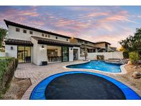 Beautiful backyard with a pool, spa, and trampoline at dusk at 22317 N 39Th Run, Phoenix, AZ 85050