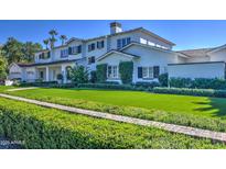 Beautiful two-story home with manicured lawn, mature trees, and a white exterior at 5819 E Calle Del Media --, Phoenix, AZ 85018