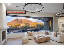 New construction living room with modern lighting, fireplace, mountain view, and a neutral color palette at 6038 E Agave Cir, Carefree, AZ 85377