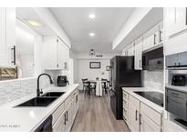 Bright kitchen features white cabinetry, modern appliances, a black faucet, and an adjacent dining area at 628 Leisure World --, Mesa, AZ 85206