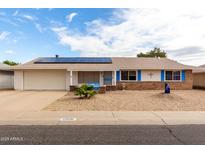 Charming single-story home with solar panels, blue trim, and low-maintenance desert landscaping at 12630 W Crystal Lake Dr, Sun City West, AZ 85375