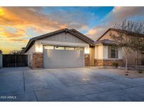 Charming single-story home featuring a two-car garage, stone accents, and manicured landscaping at 17618 W Paraiso Dr, Surprise, AZ 85387