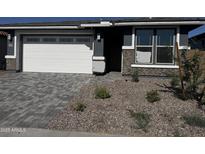 Charming single Gathering home featuring a manicured stone yard and two car garage at 21495 N Rummler Ln, Maricopa, AZ 85138