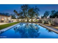 Stunning pool with a large tree in the background reflecting on the water at twilight at 22619 N La Senda Dr, Scottsdale, AZ 85255