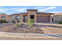 Charming single-story home featuring a desert landscape, stone accents and a tile roof at 7717 W Noble Prairie Way, Florence, AZ 85132