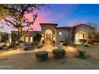 Stunning home featuring charming landscaping and a picturesque wrought iron gate entrance at sunset at 9290 E Thompson Peak Pkwy # 142, Scottsdale, AZ 85255