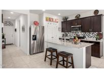 Bright kitchen features stainless steel appliances, speckled granite countertops, and tiled floors at 18644 N Desert Willow Dr, Maricopa, AZ 85138
