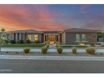 Elegant home boasts professional landscaping, stone accents, and a well-lit path leading to the front door at 19912 E Natalie Way, Queen Creek, AZ 85142