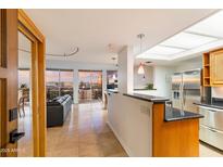 Modern living area with a black leather sofa, tiled floors and a view of the cityscape at 2323 N Central Ave # 1902, Phoenix, AZ 85004