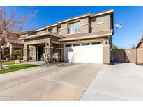 Two-story home featuring an attached two-car garage and a well-maintained front yard at 44560 W Copper Trl, Maricopa, AZ 85139