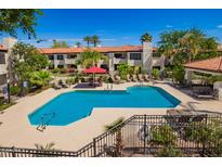Community pool featuring lounge chairs, lush landscaping, and a clear blue swimming area at 9990 N Scottsdale Rd # 2049, Paradise Valley, AZ 85253