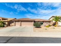 Charming single-story home featuring a three car garage and desert landscaping at 11056 E Nopal Ave, Mesa, AZ 85209