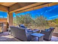 Outdoor living space with built-in grill, fire pit, and comfortable seating with desert views at 11656 N 135Th Pl, Scottsdale, AZ 85259