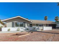 Charming single-story home featuring a well-maintained yard and a cozy outdoor space, with a clean white brick perimeter at 1206 E Loyola Dr, Tempe, AZ 85282