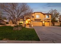 Inviting two-story home with a well-manicured lawn, a driveway, and a large tree in the front yard at 15011 N 45Th Pl, Phoenix, AZ 85032