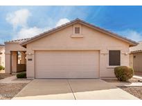 Beige two-car garage in front of a home with neutral tones and desert landscaping beneath a partly cloudy sky at 2429 E Valencia Dr, Casa Grande, AZ 85194