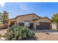 Charming single-story home with tan stucco, desert landscaping, and a two-car garage at 45341 W Paraiso Ln, Maricopa, AZ 85139